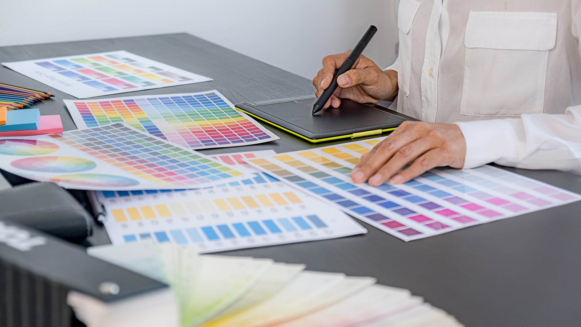 Male Graphic Designer with Colored Templates on Table